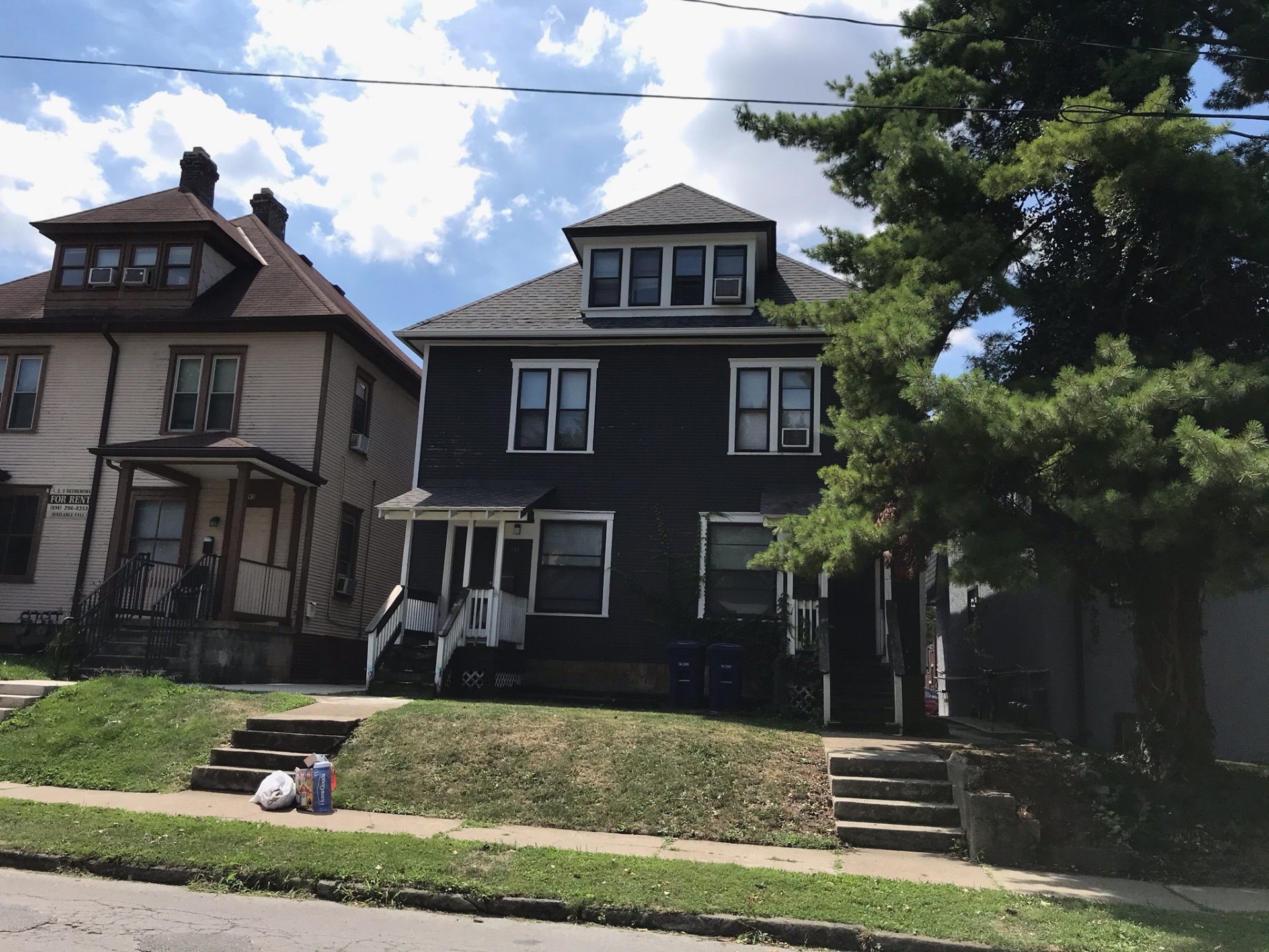 89 E Woodruff Ave. exterior — historic dark-sided home with covered porches, a short walk to campus