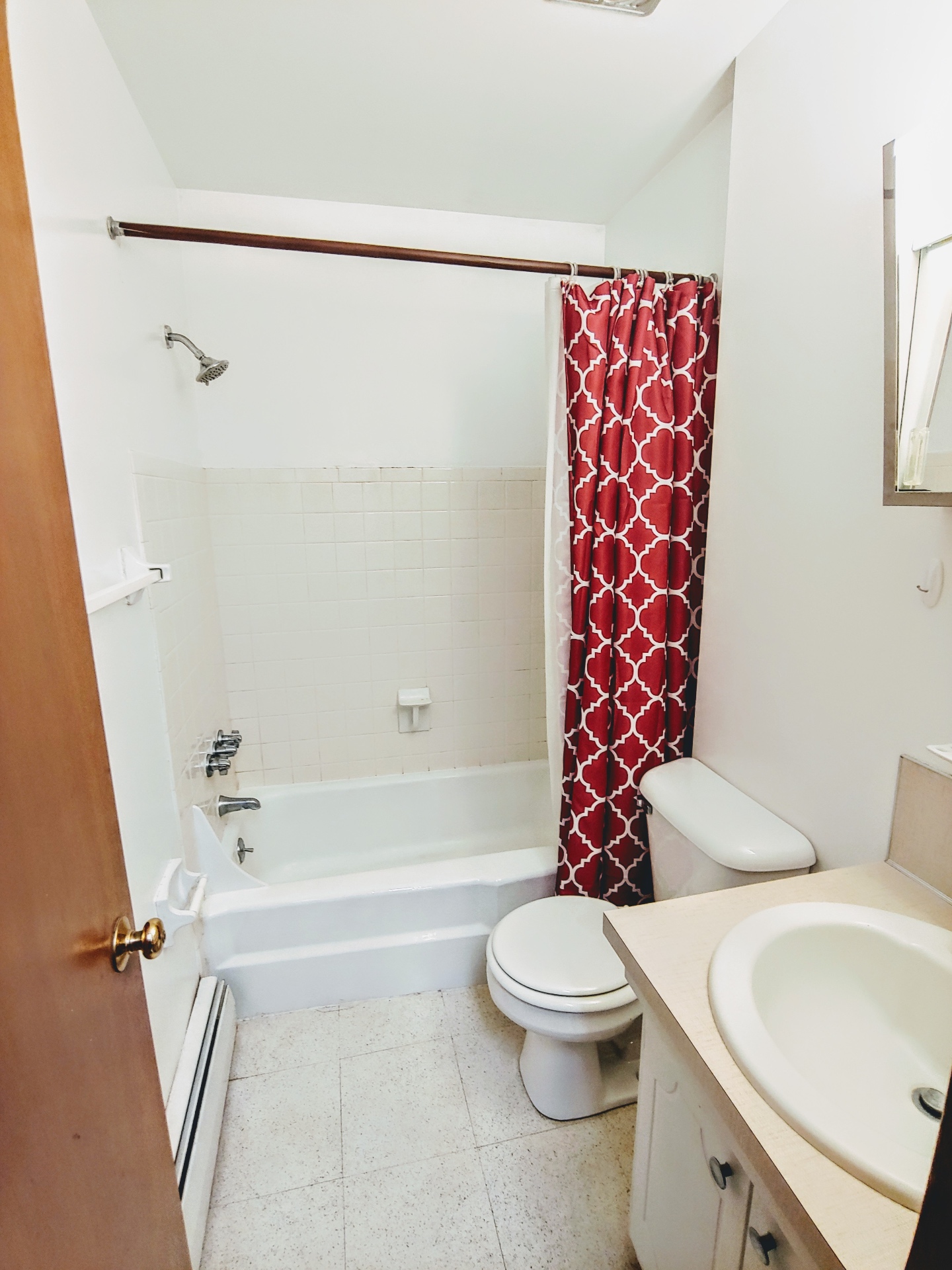 2040 Iuka Ave. 5B bathroom with white tiled tub-shower, red patterned curtain, and vanity