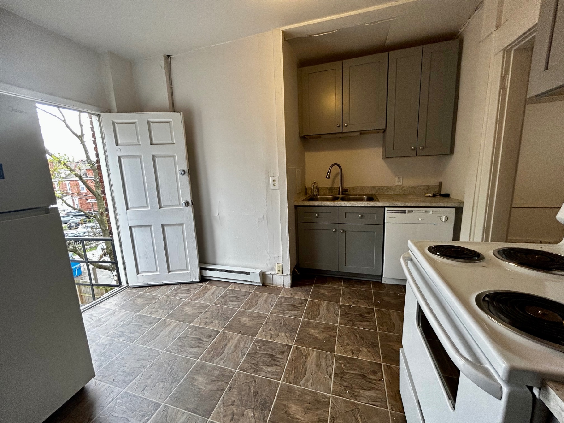 1820 Summit St. galley kitchen with sink, gray cabinetry, and exterior door off the back