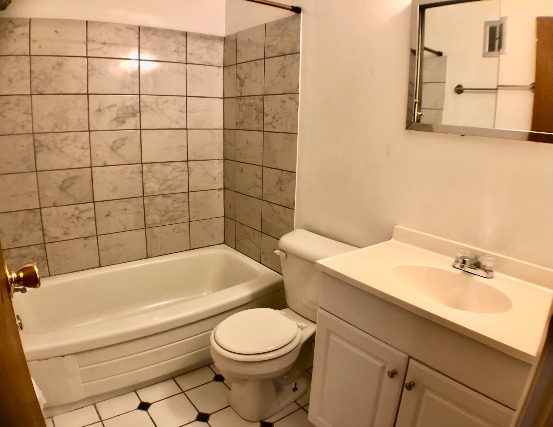 1827 N 4th St. Unit 1 bathroom with pedestal-style vanity, tub, and tiled walls