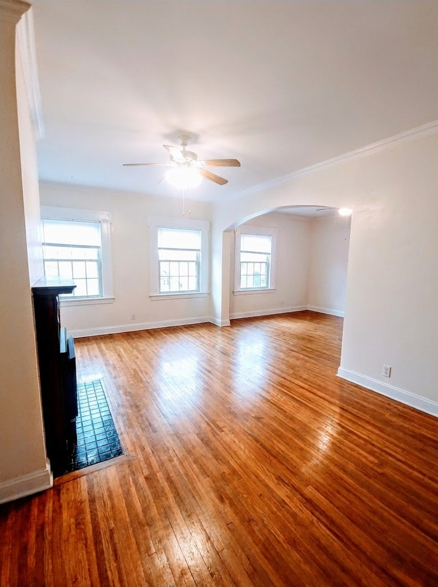 Unit I living room with open floor plan, arched entry, and hardwood floors