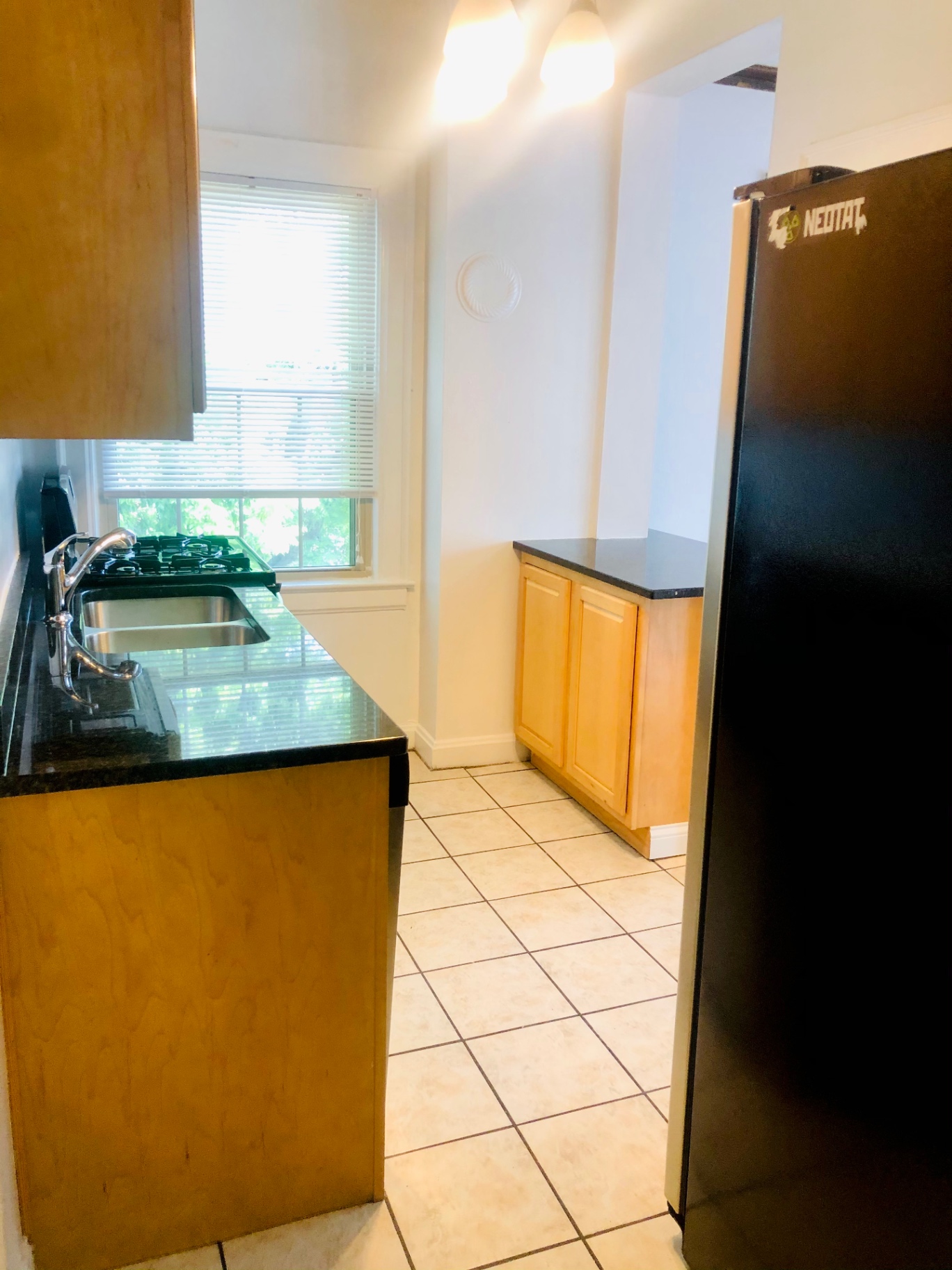 Unit L kitchen with granite countertops, gas range, and stainless steel sink