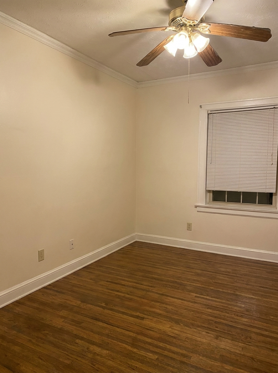 Unit H second bedroom with ceiling fan and hardwood floors