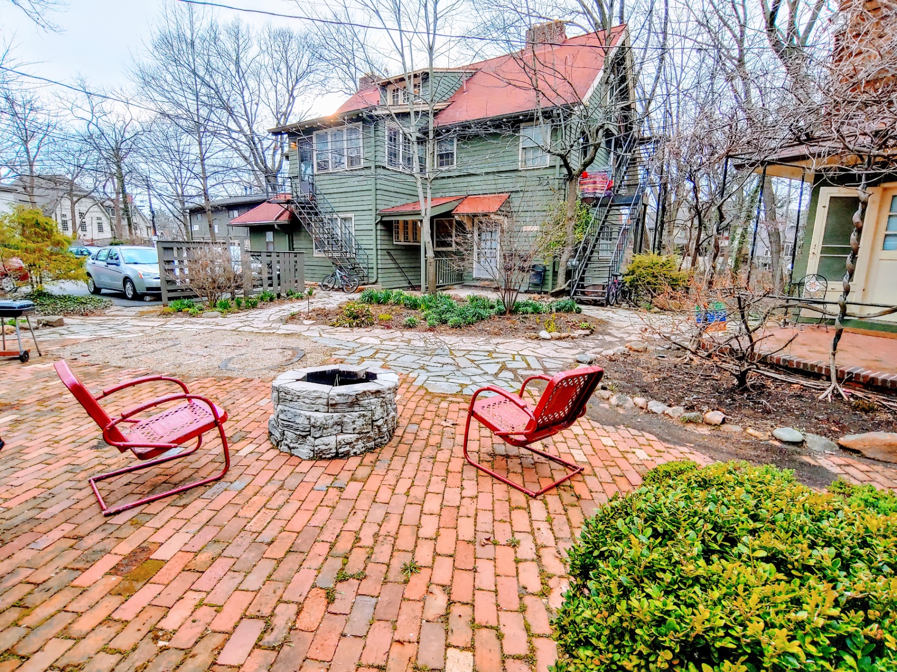 2026 Iuka Ave shared brick courtyard with fire pit and vintage red chairs