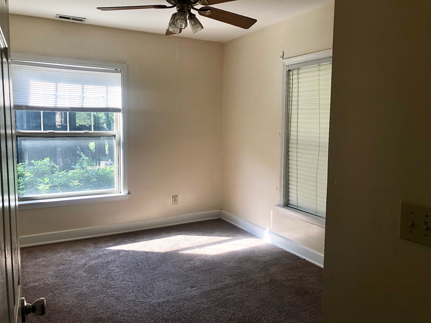 2034 Iuka Ave A carpeted bedroom with ceiling fan and two large windows