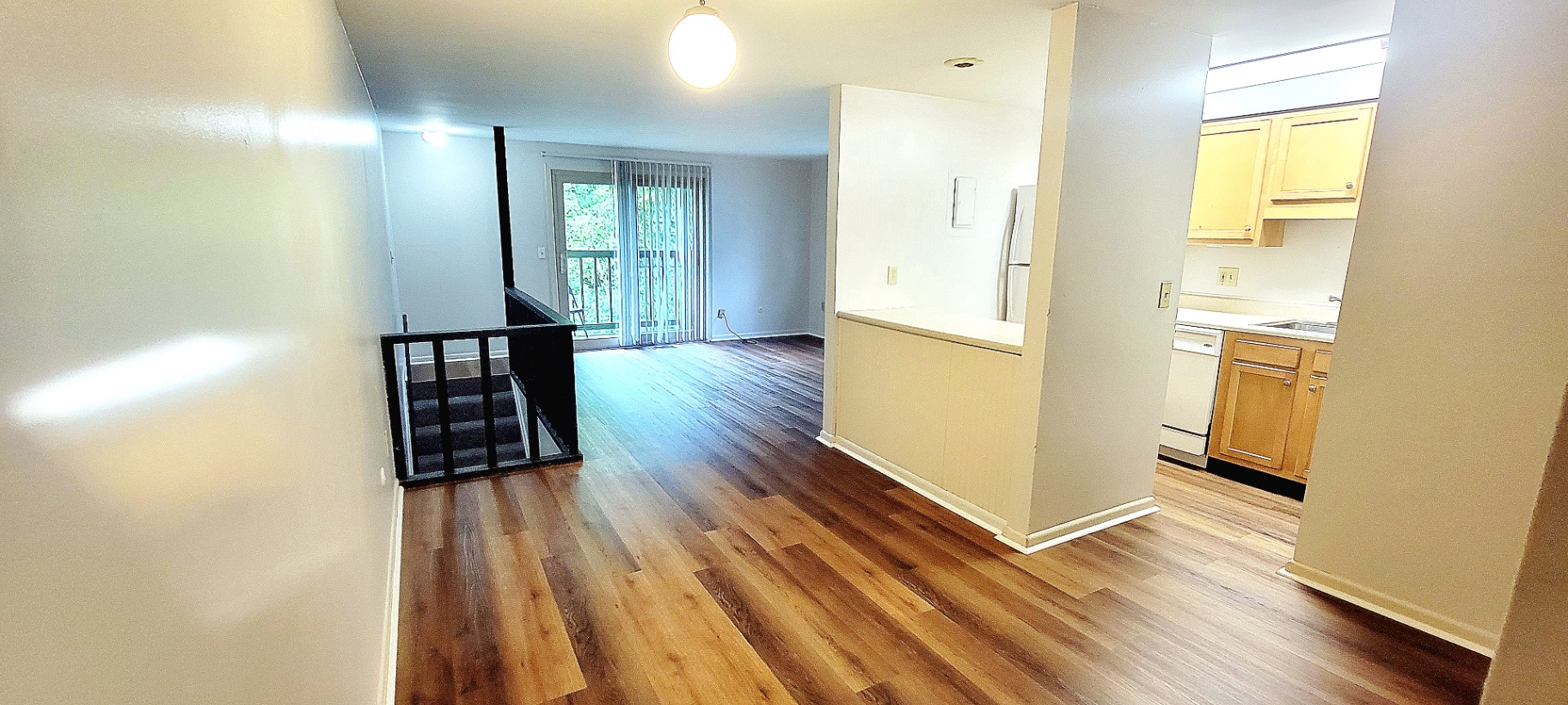 2022 Summit St. open main living area with plank floors, kitchen pass-through, and view toward the balcony