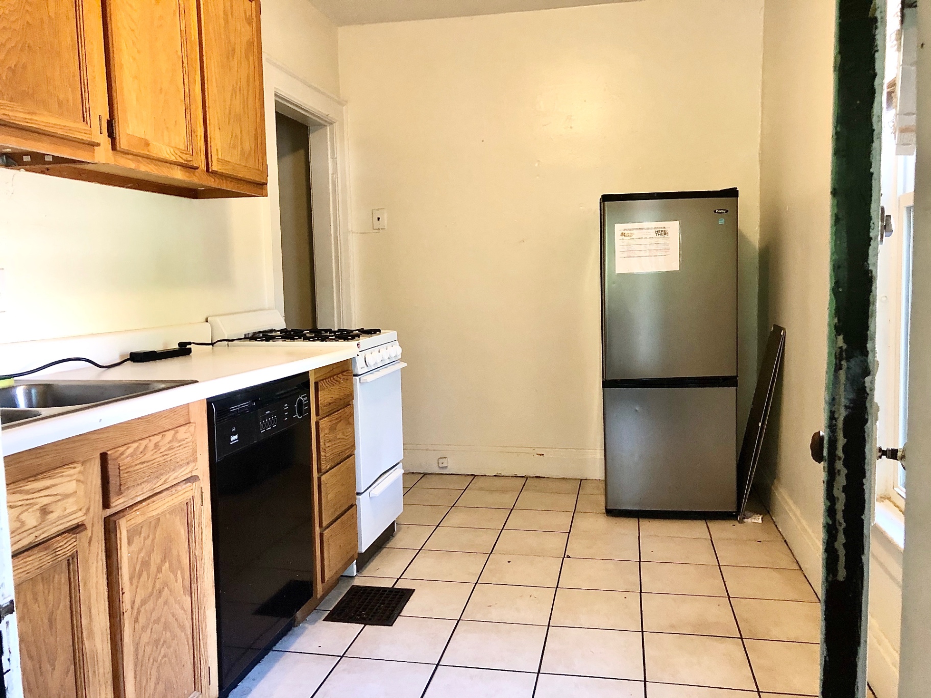 372 B E 14th Ave. kitchen with oak cabinets, dishwasher, gas range, and stainless fridge