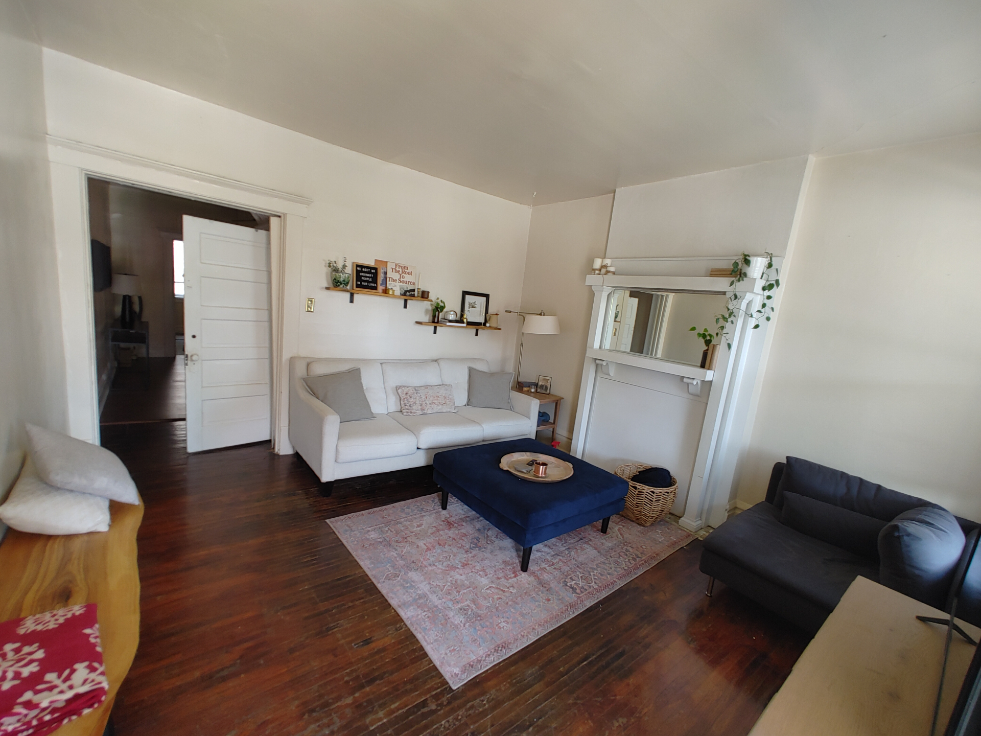 121 W 9th living room view toward dining with white sofa and original mantel