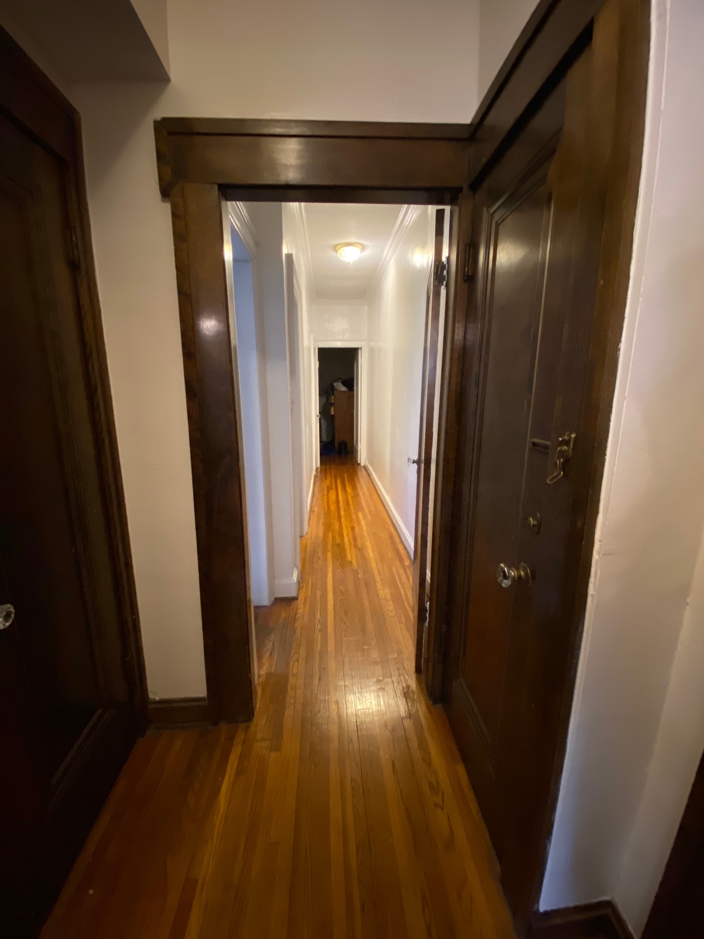 Unit E hallway with dark wood trim and hardwood floors