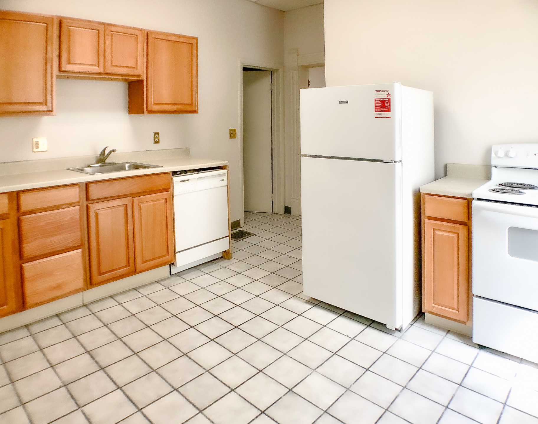 Unit A kitchen with maple cabinets, dishwasher, full-size fridge and electric range