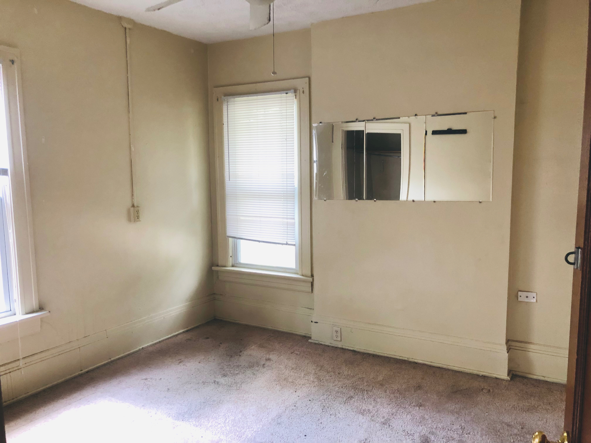 2005 Summit St. carpeted bedroom with large window and wall mirror