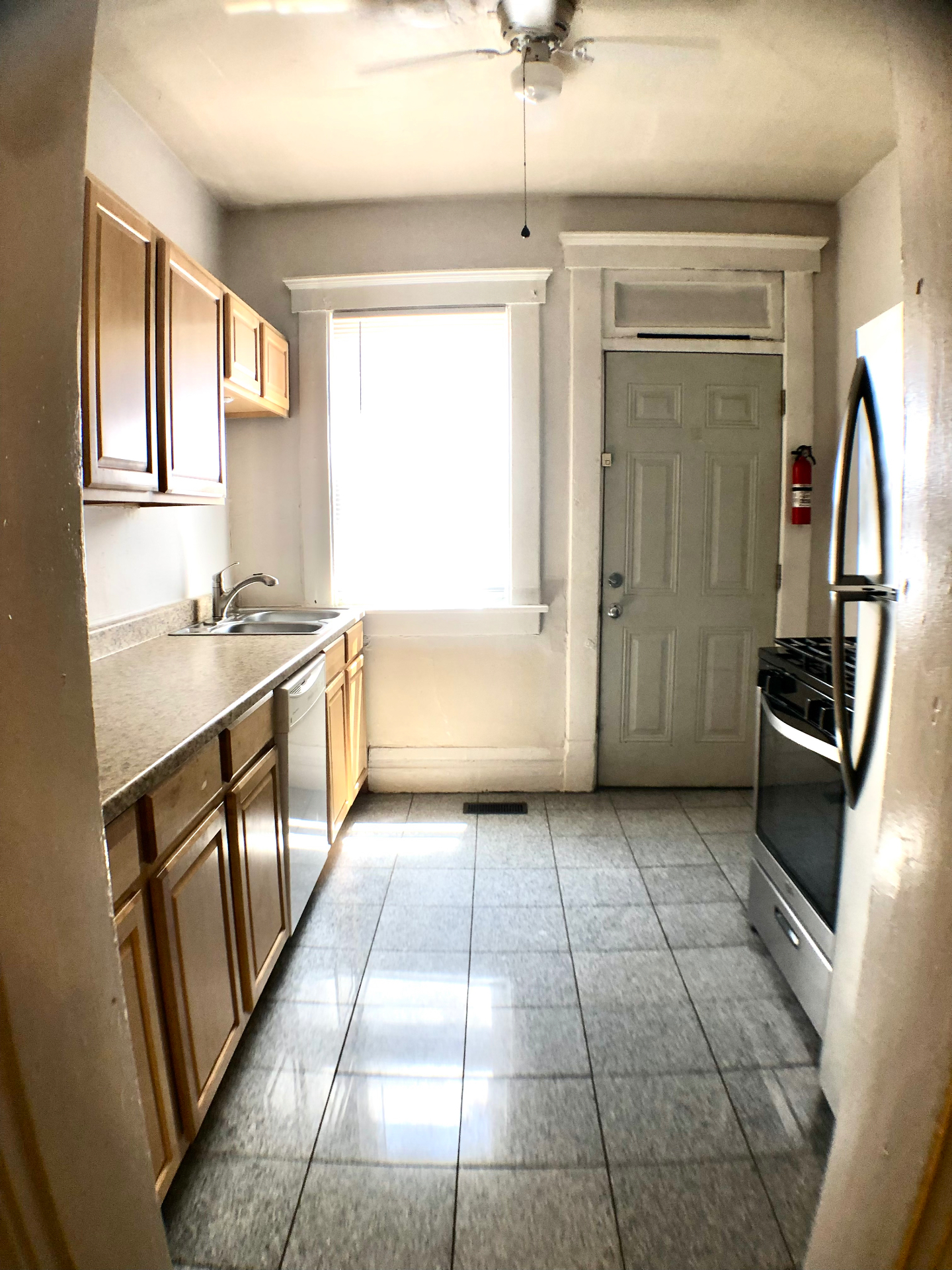 117 W 9th galley kitchen with stainless gas range, dishwasher and side door