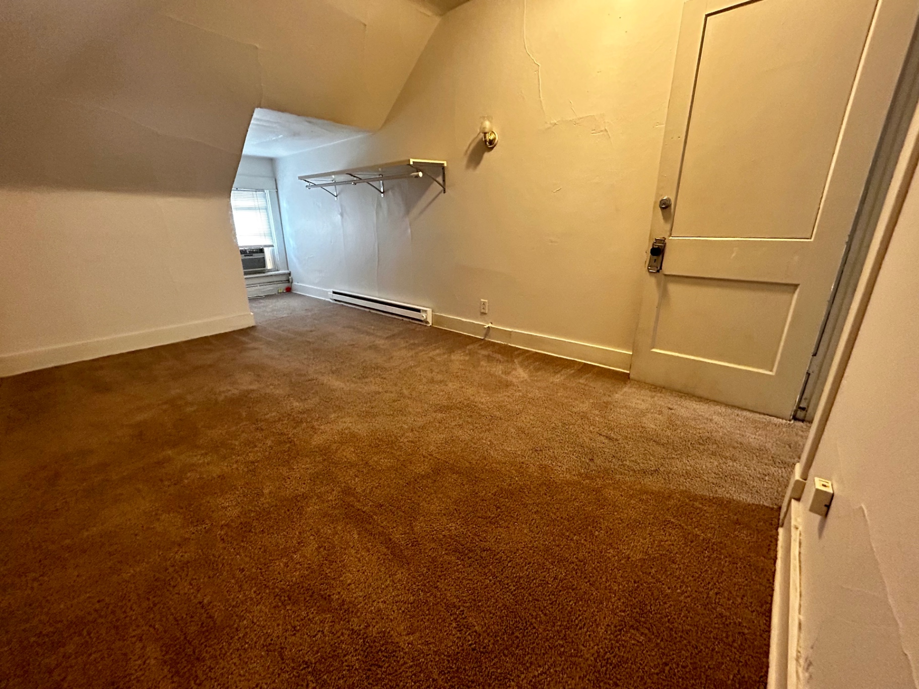 1820 Summit St. upper room with broad carpeted layout, wall sconce, and sloped ceiling lines