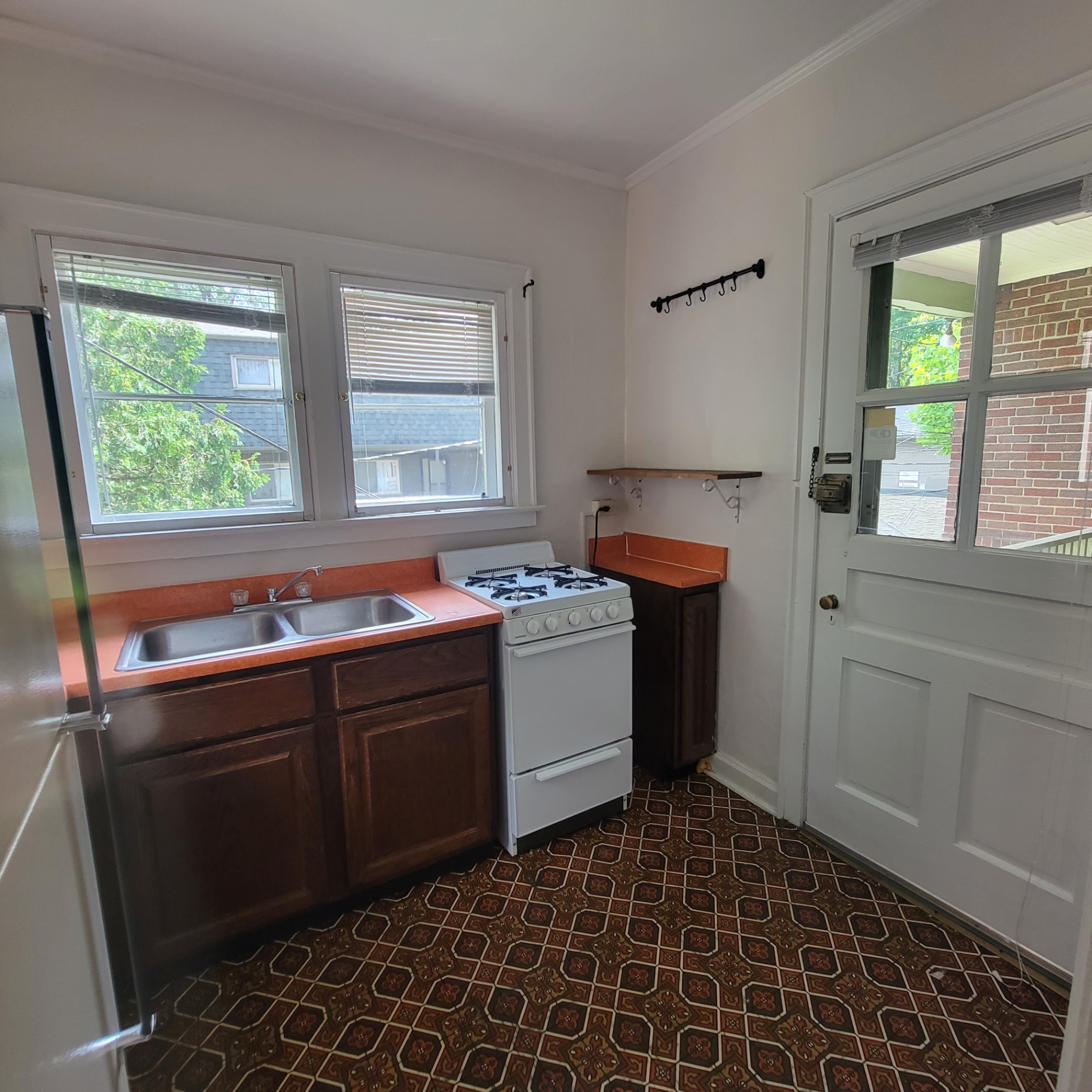 2048 Iuka Ave. C kitchen with gas range, rear door, and bright windows above the sink