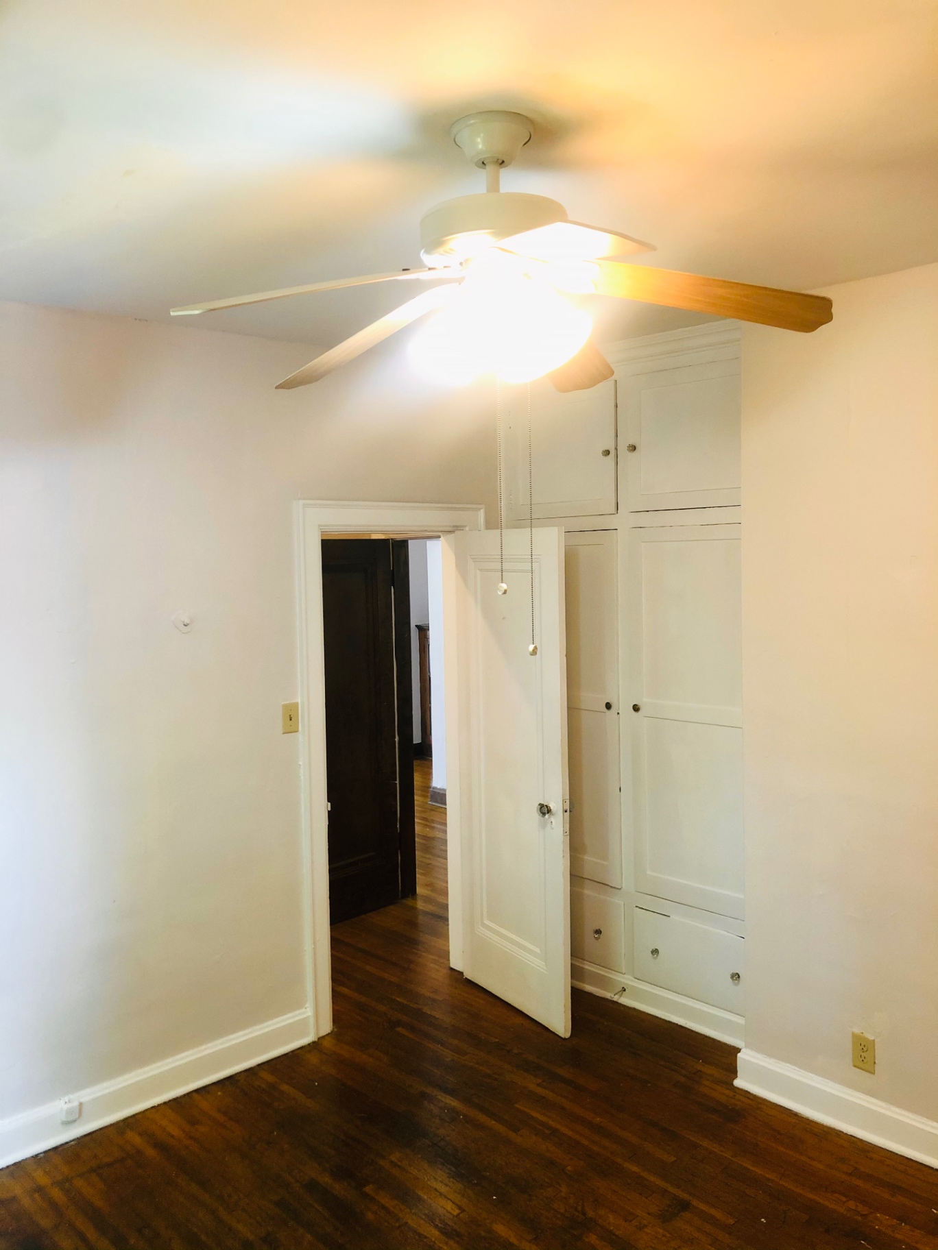 Unit L second bedroom with built-in cabinets and ceiling fan