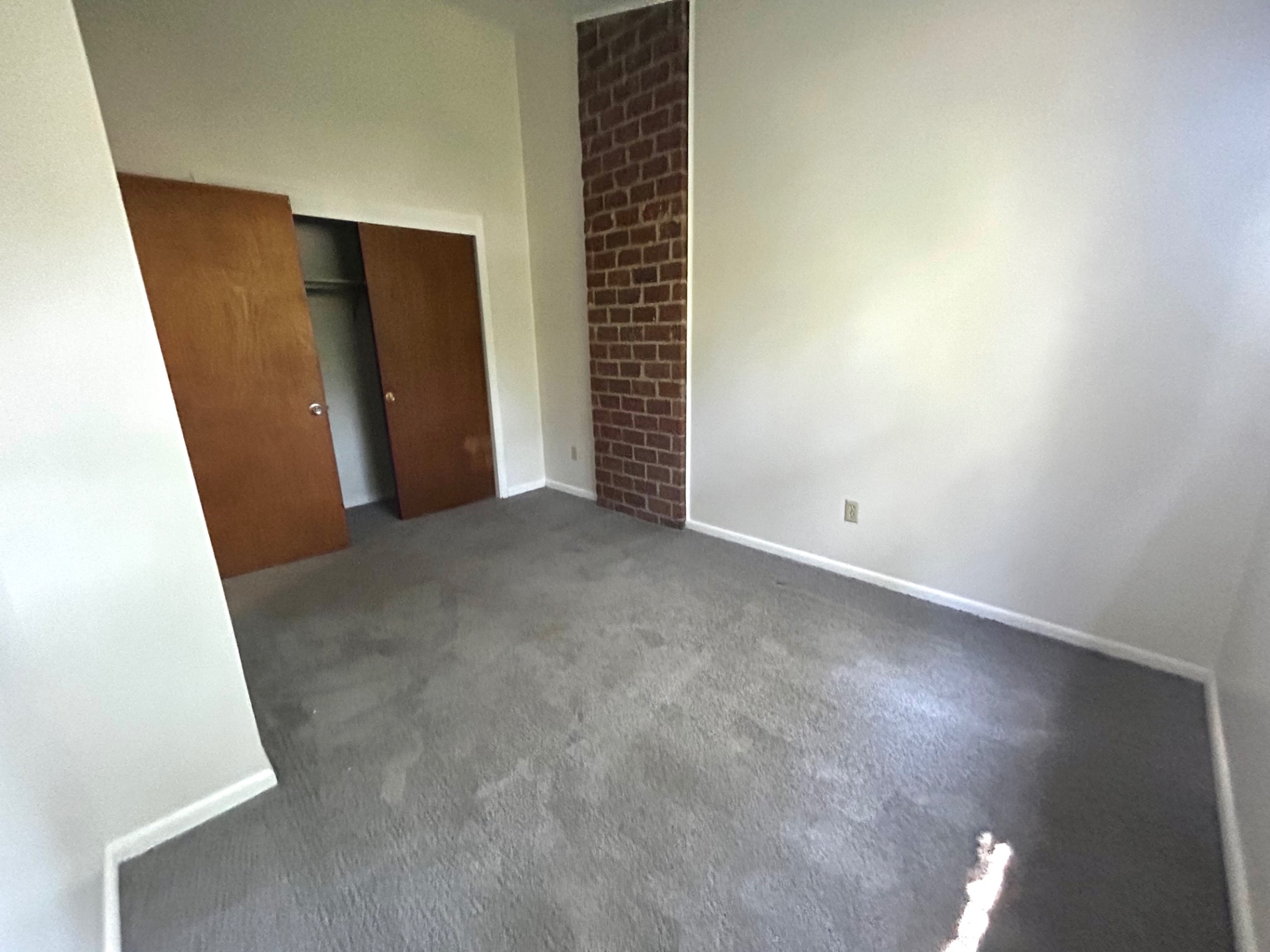 2011 Summit St. Unit E second bedroom with exposed brick accent and open closet