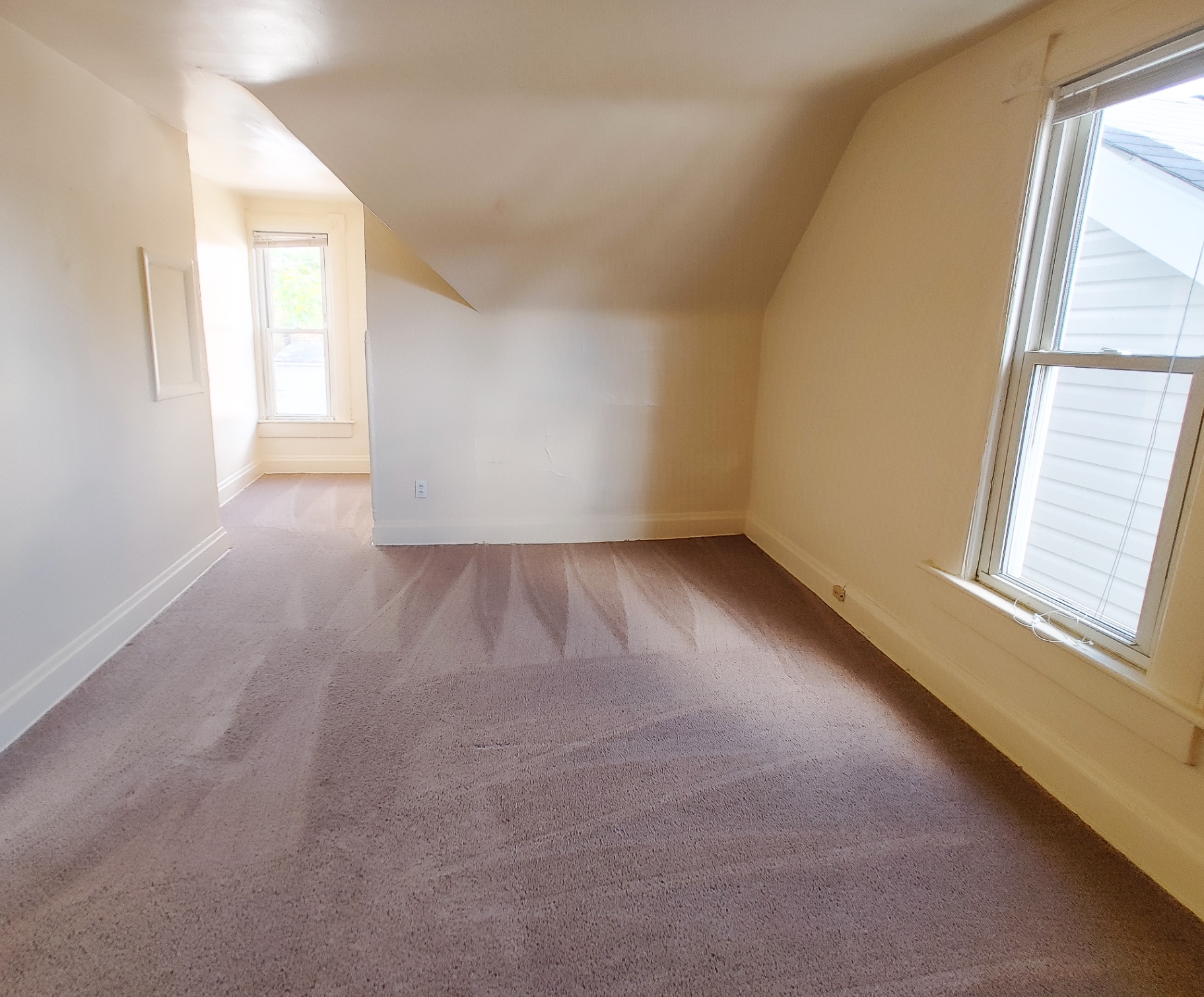 Rear unit upstairs bedroom with dormer walls, two windows and fresh carpet