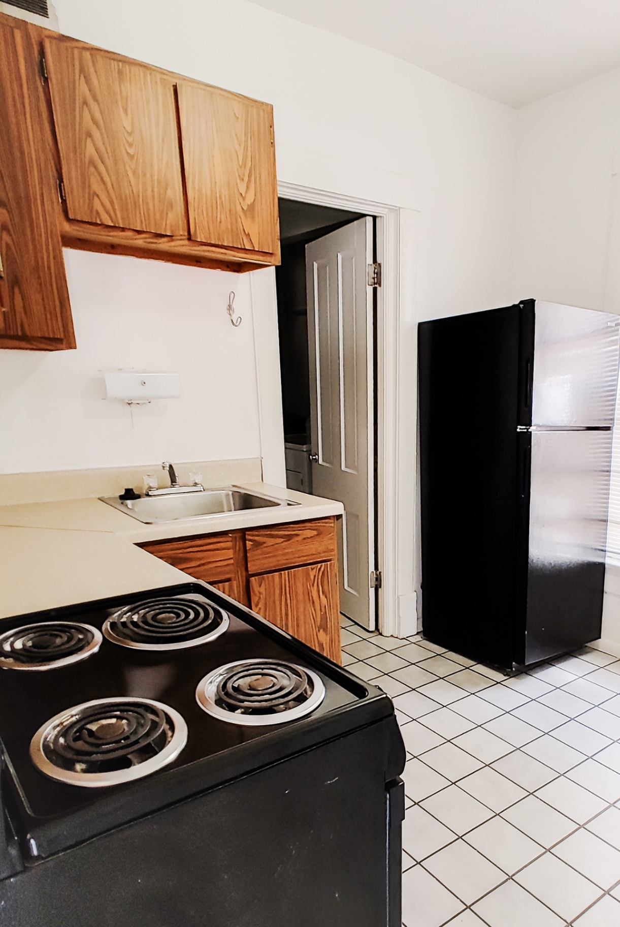 Rear unit kitchen with electric range, sink and full-size fridge