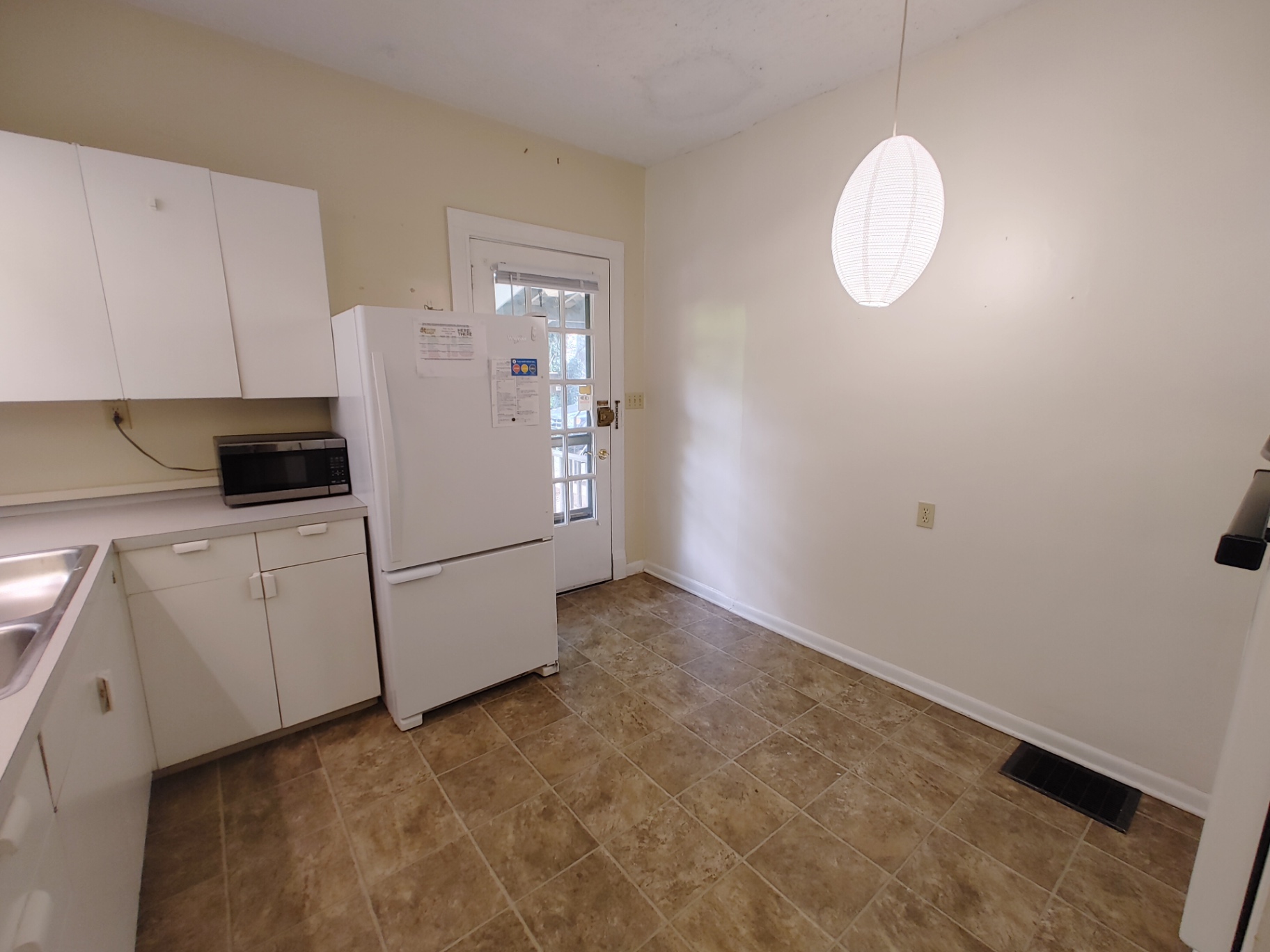 2026 Iuka Ave B kitchen with full-size refrigerator, microwave, and rear door to porch