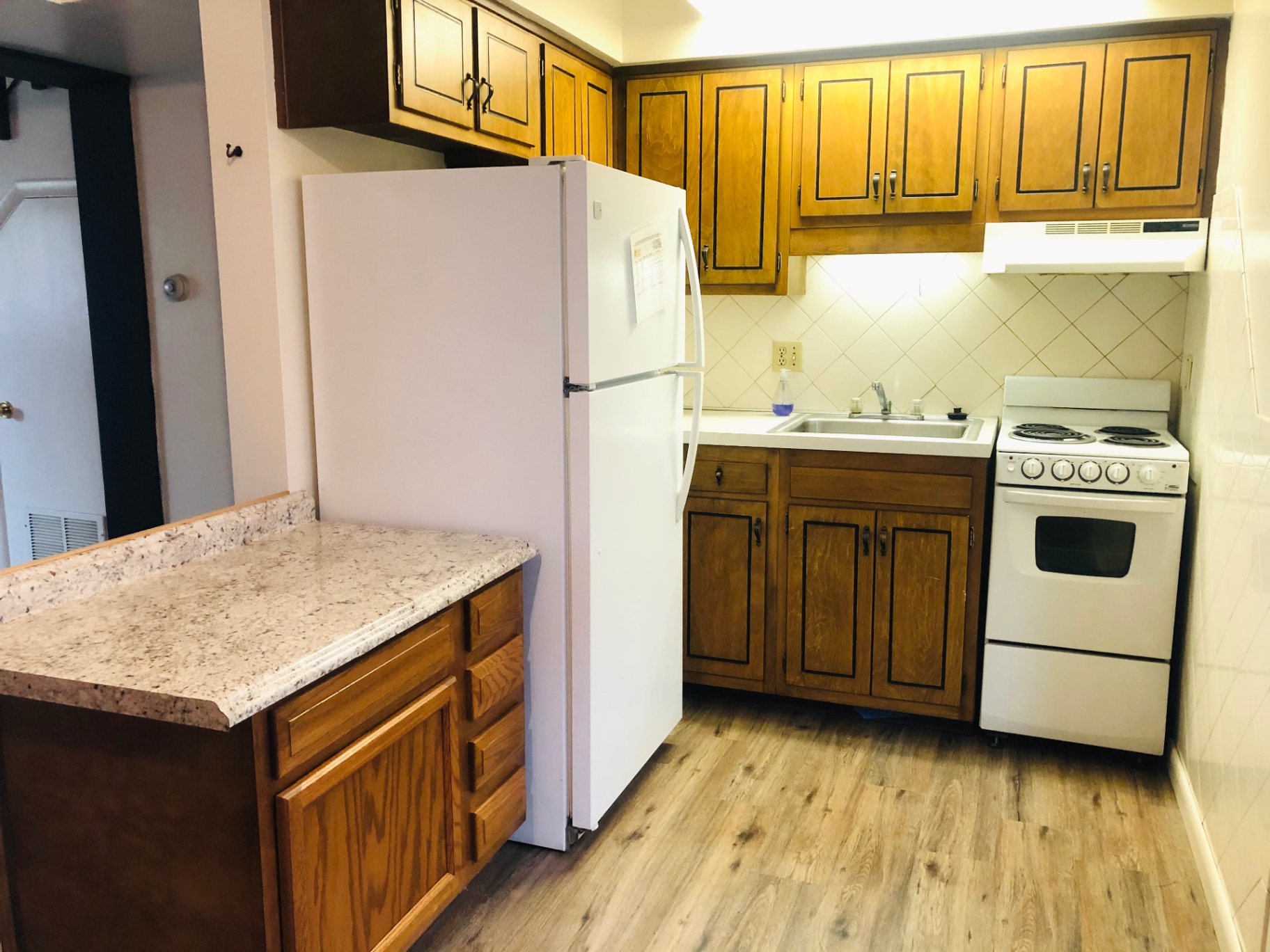 2011 Summit St. Unit B kitchen with wood cabinets, updated countertops, and white appliances