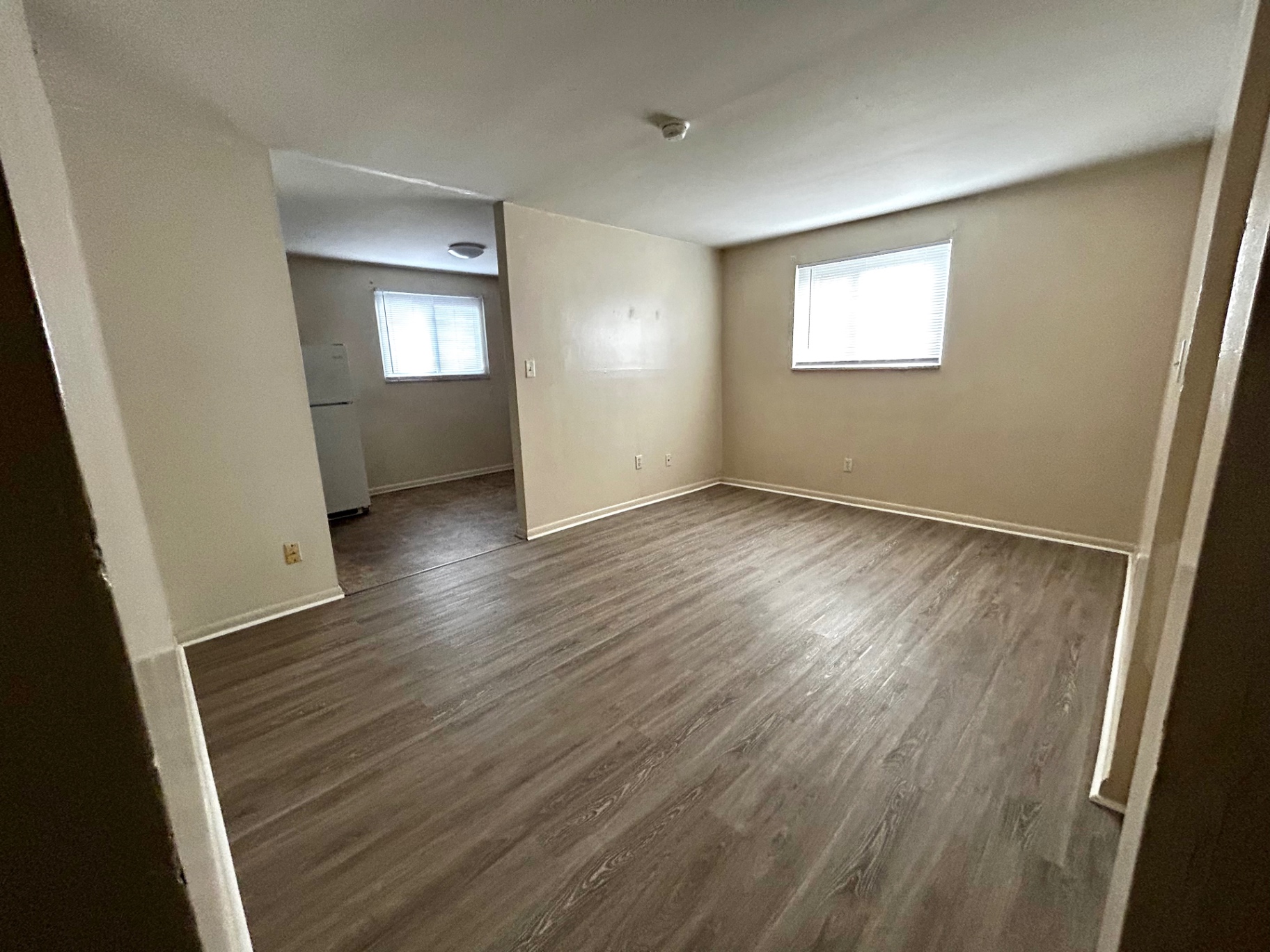 2150 N 4th St. Unit B living room with plank flooring, bright window, and view into kitchen