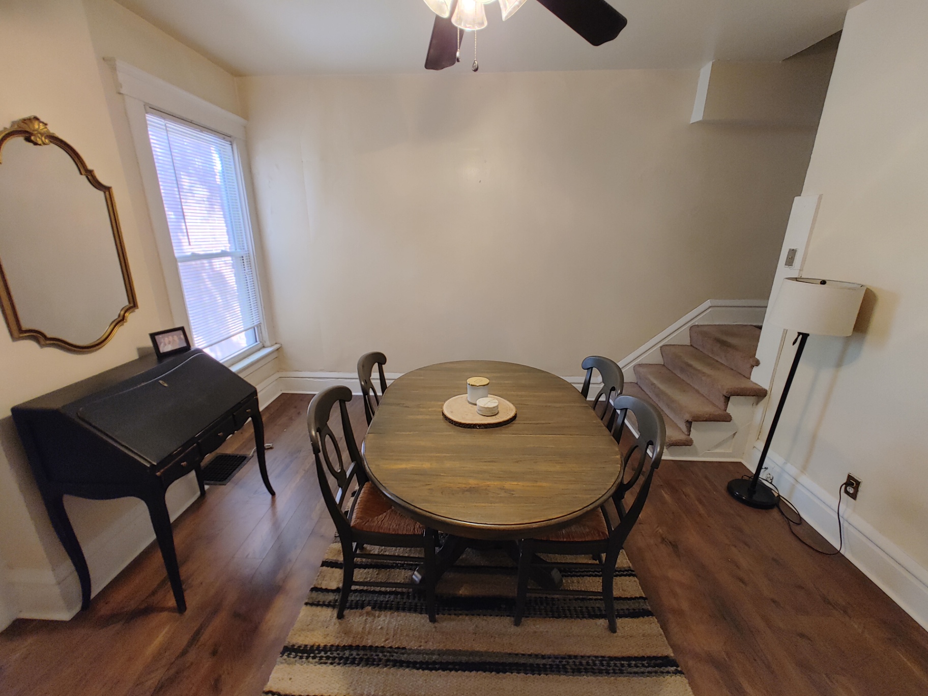 117 W 9th dining area with oval wood table and antique writing desk