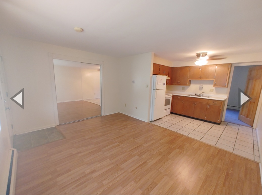 1827 N 4th St. Unit 7 open living and kitchen area with wood-look flooring and mirrored closet doors