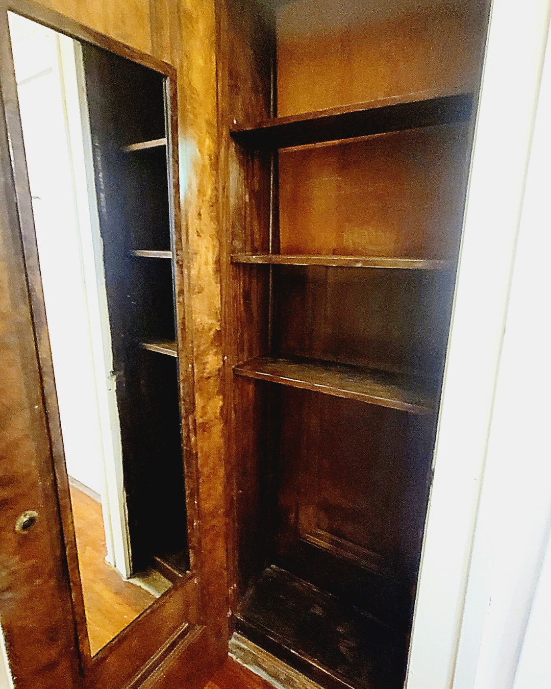 Unit A built-in wood cabinet with shelves and mirrored door