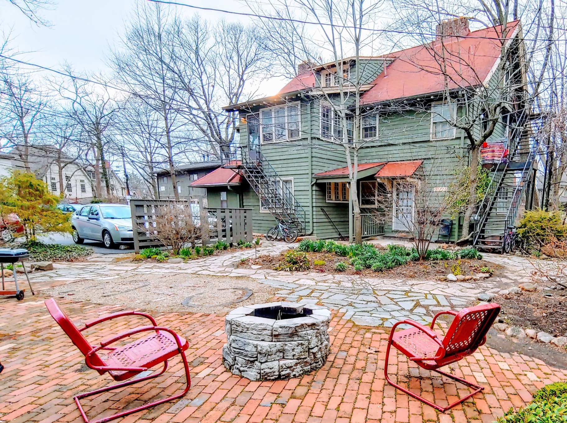2040 Iuka Ave. 1B shared brick courtyard with stone fire pit and green building exterior