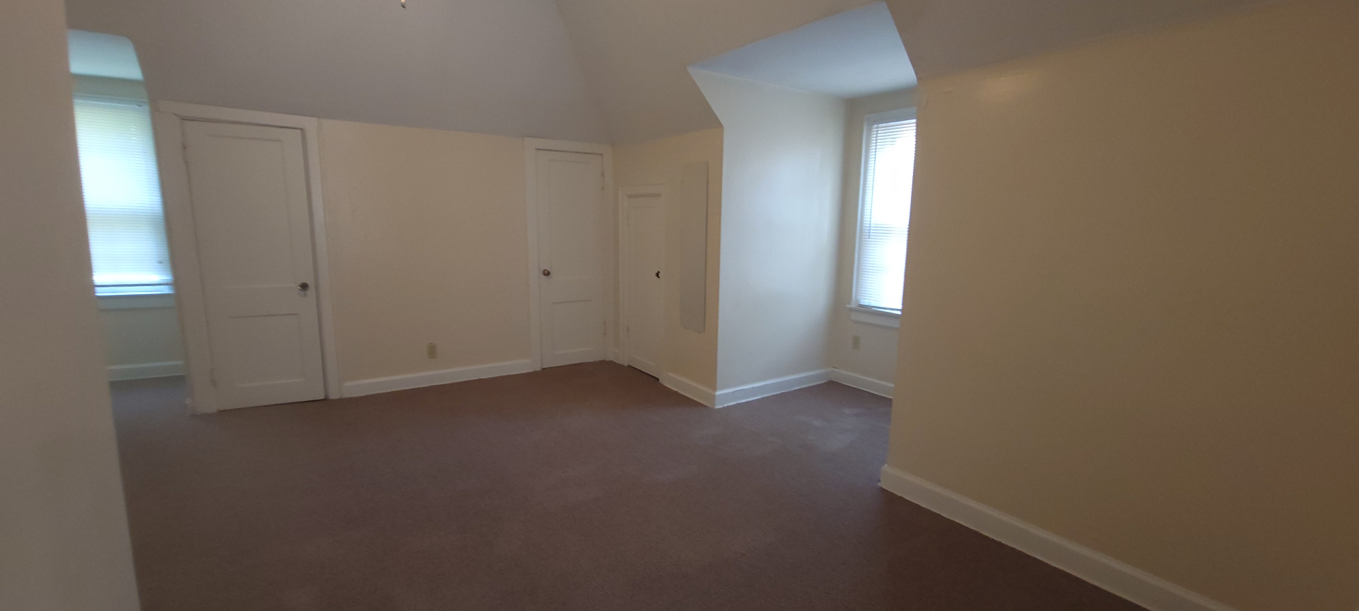 2054 Iuka Ave. C upstairs bedroom with vaulted ceiling and multiple closet doors