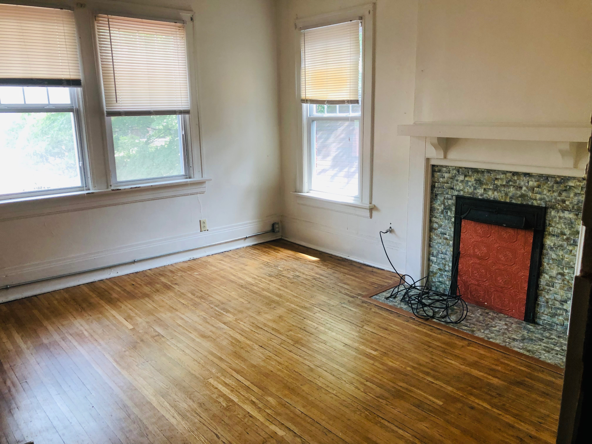 2005 Summit St. spacious living room with decorative fireplace, hardwood floors, and bright corner windows